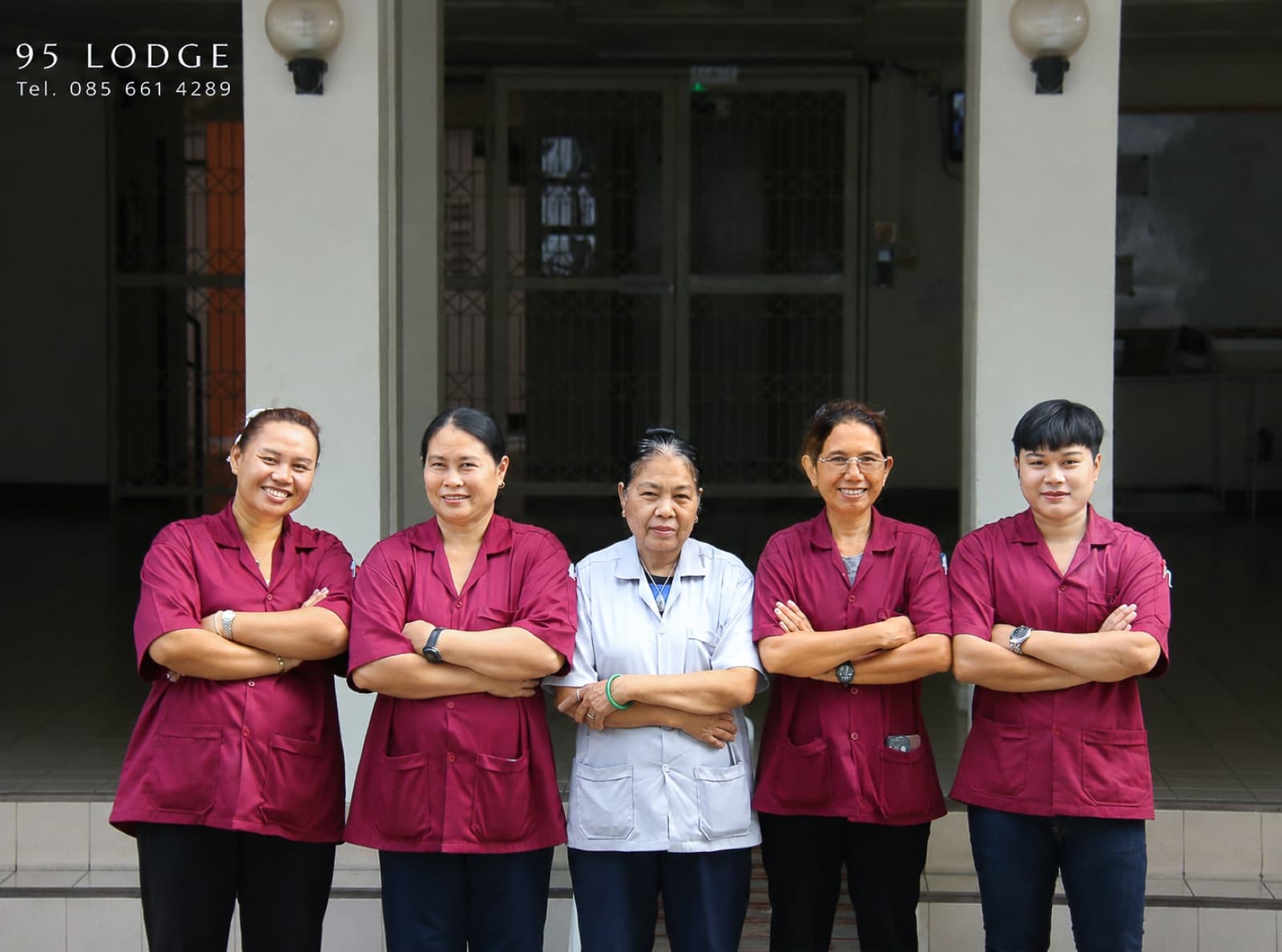Das Team des 95 Lodge am Eingang — Personal in weinroten Uniformen mit der Hausleitung in Weiß